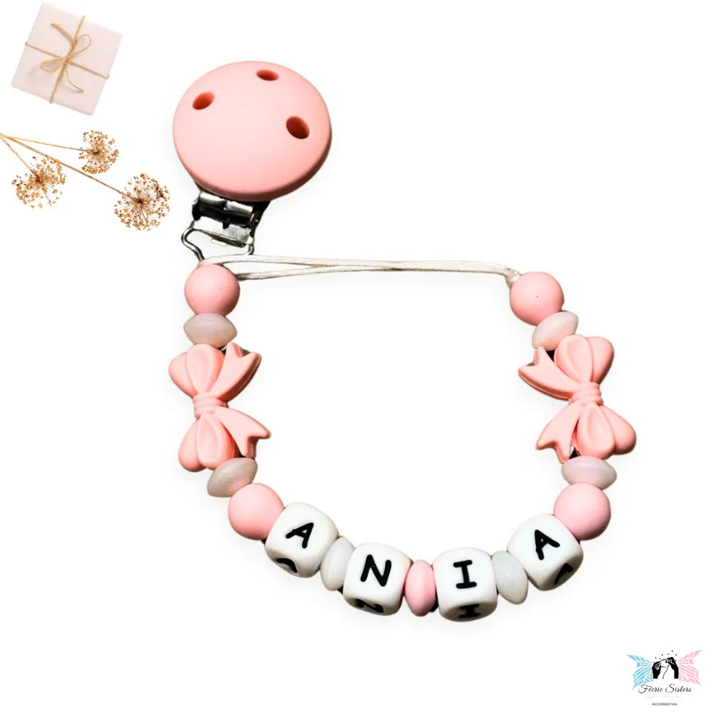 Attache tétine bébé fille personnalisée avec nœuds roses en silicone – accessoire fait main avec prénom, design élégant et sécurisé.